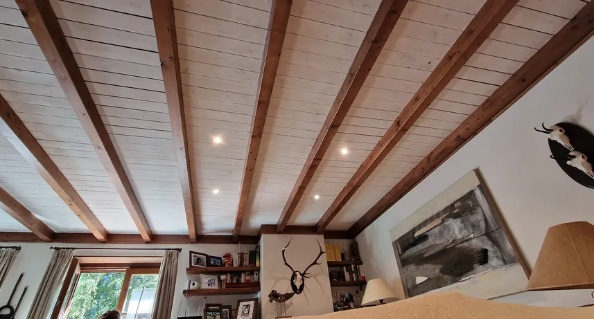 Trabajo de pintura blanca en buhardilla con vigas de madera en Salardú